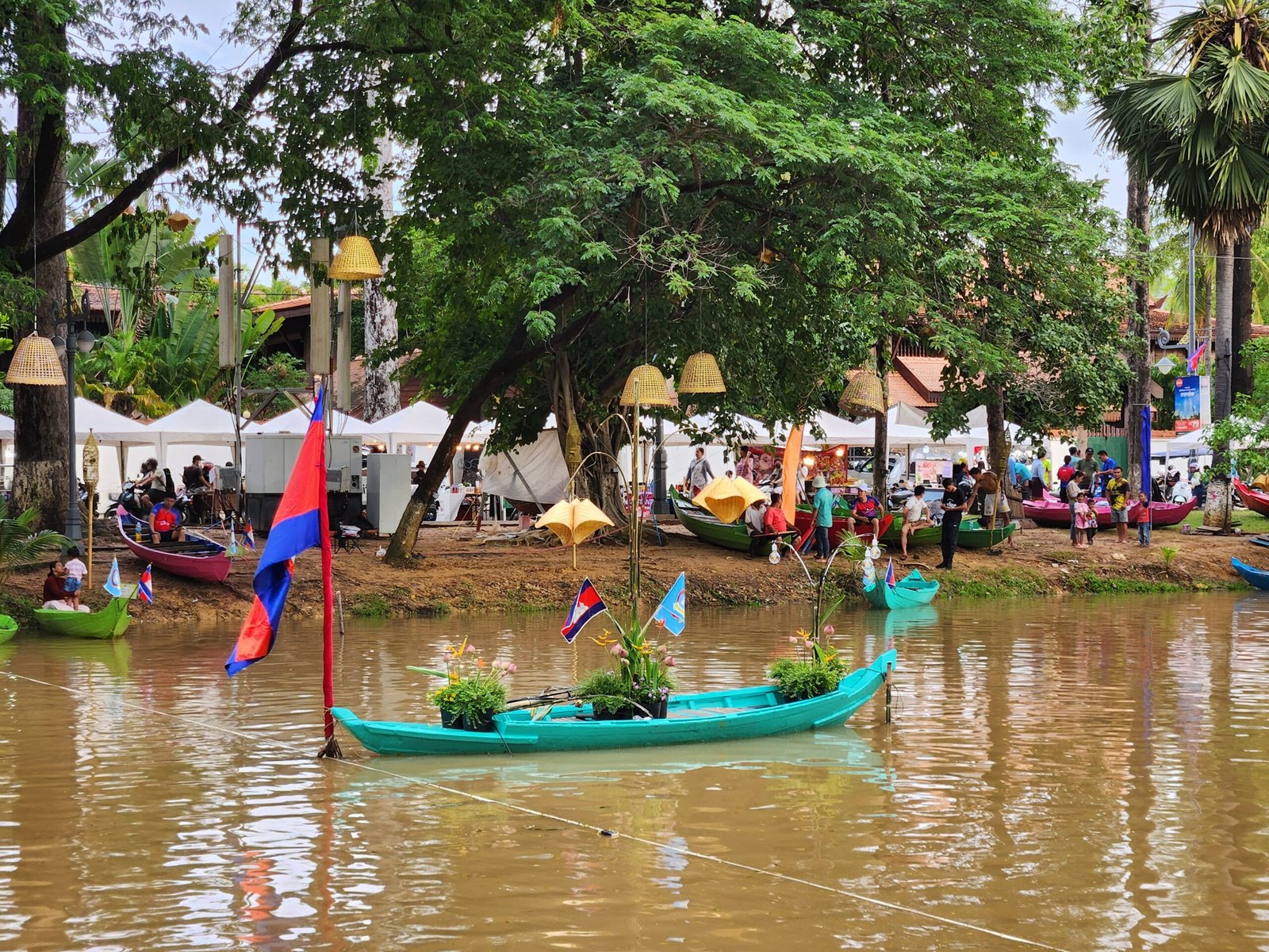 A Cambodian flag flies from a decorated float boat with plants