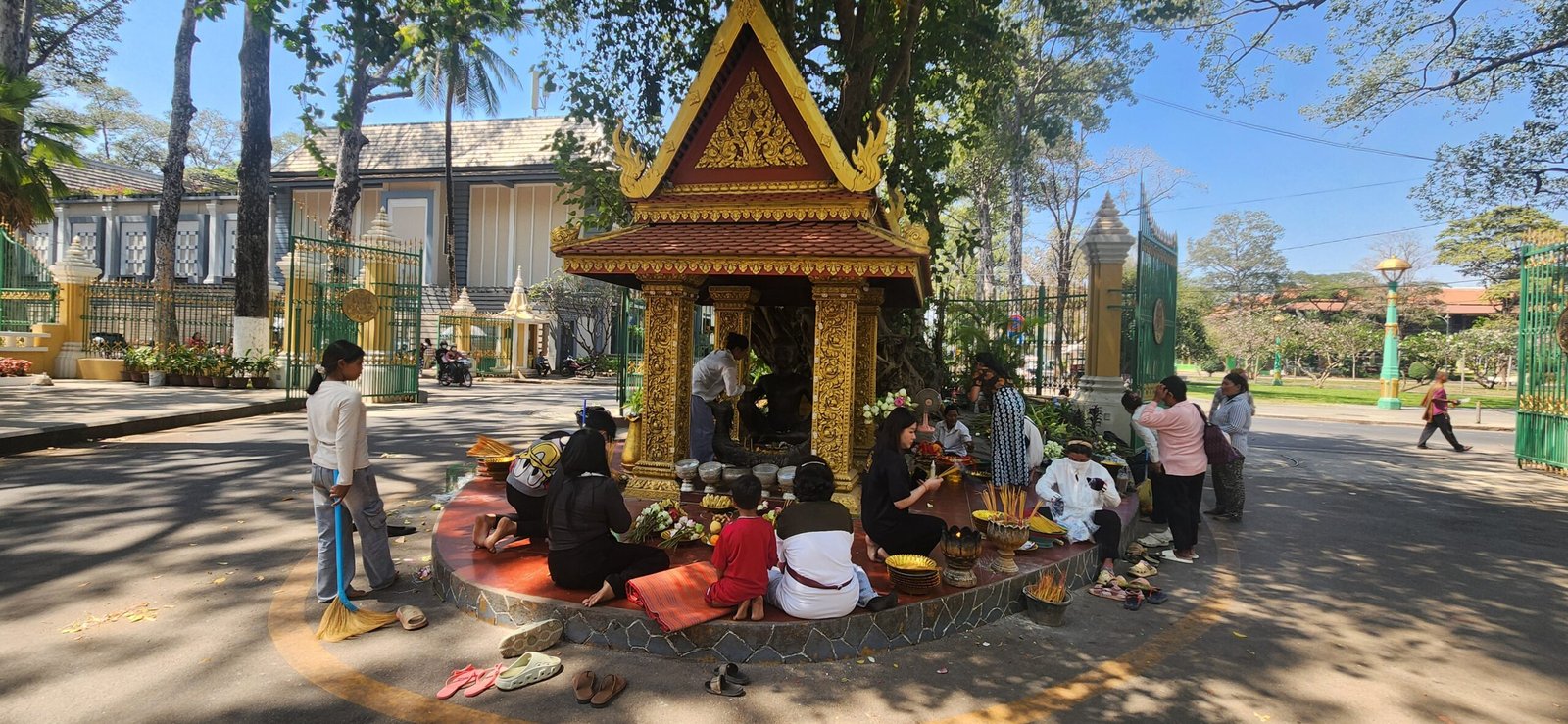 Seated worshippers before the golden Khmer pavilion