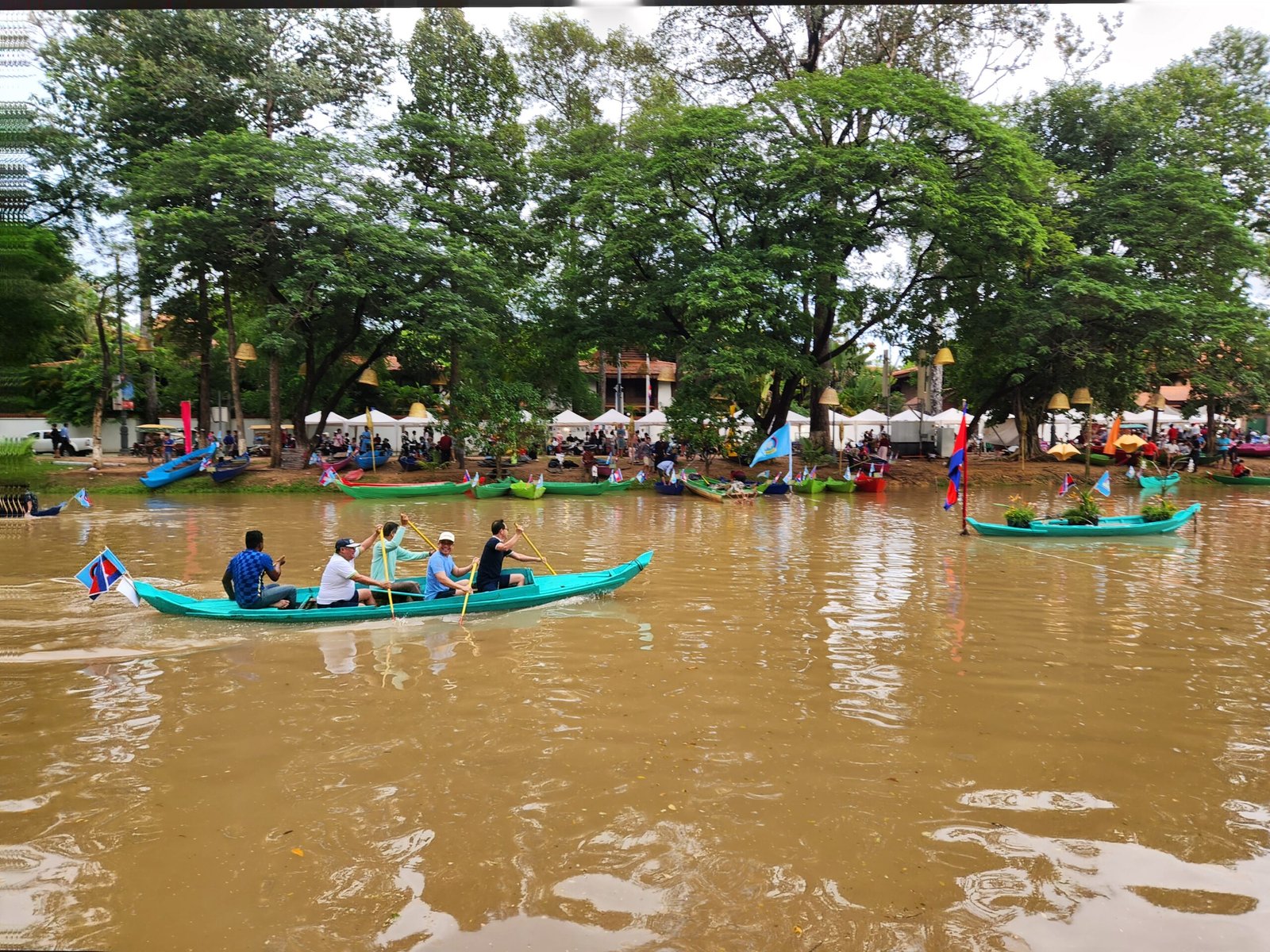 A green canoe crew rows past during the festival