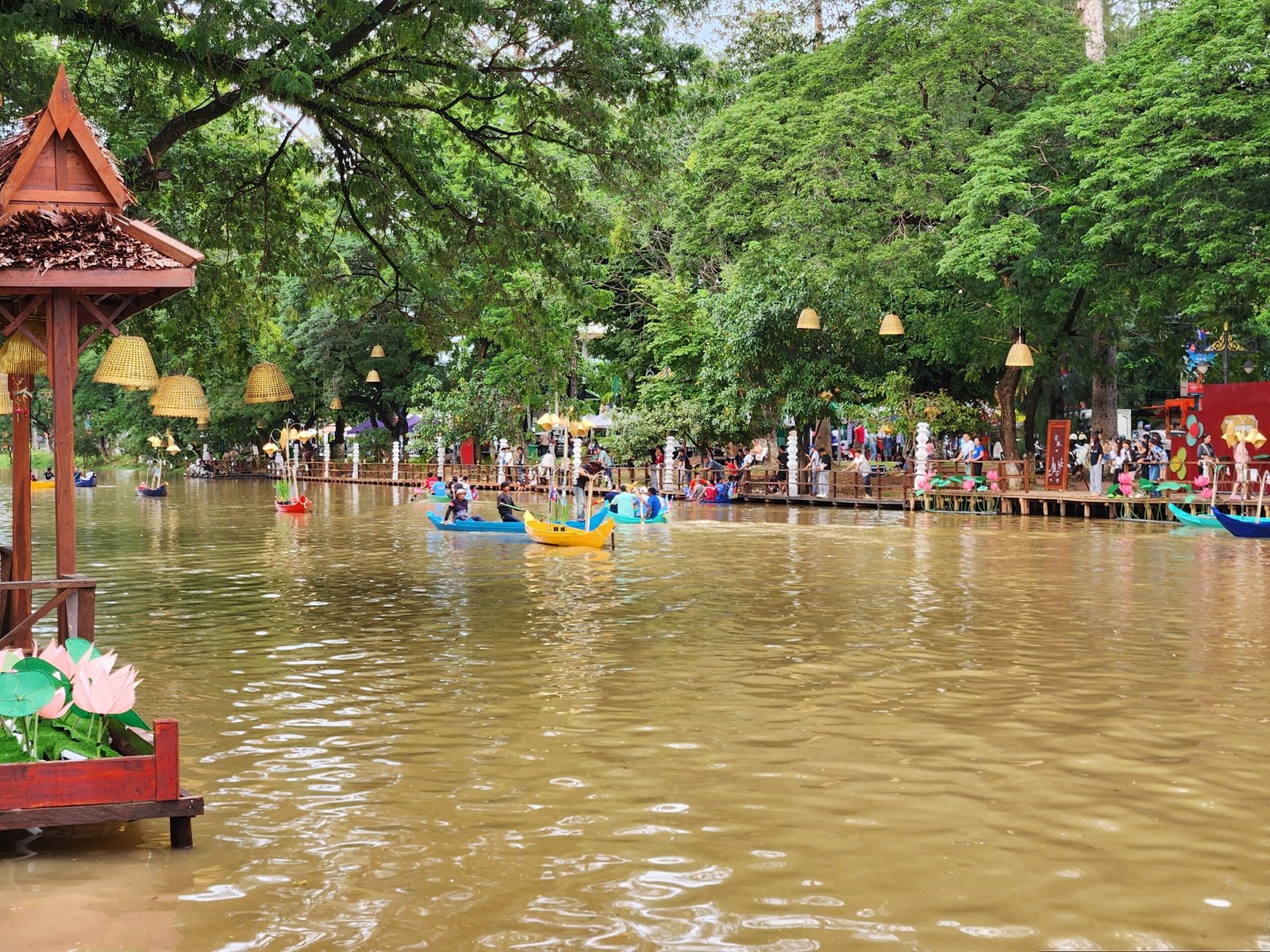 Khmer pavilion and hanging lanterns frame the boat-filled river