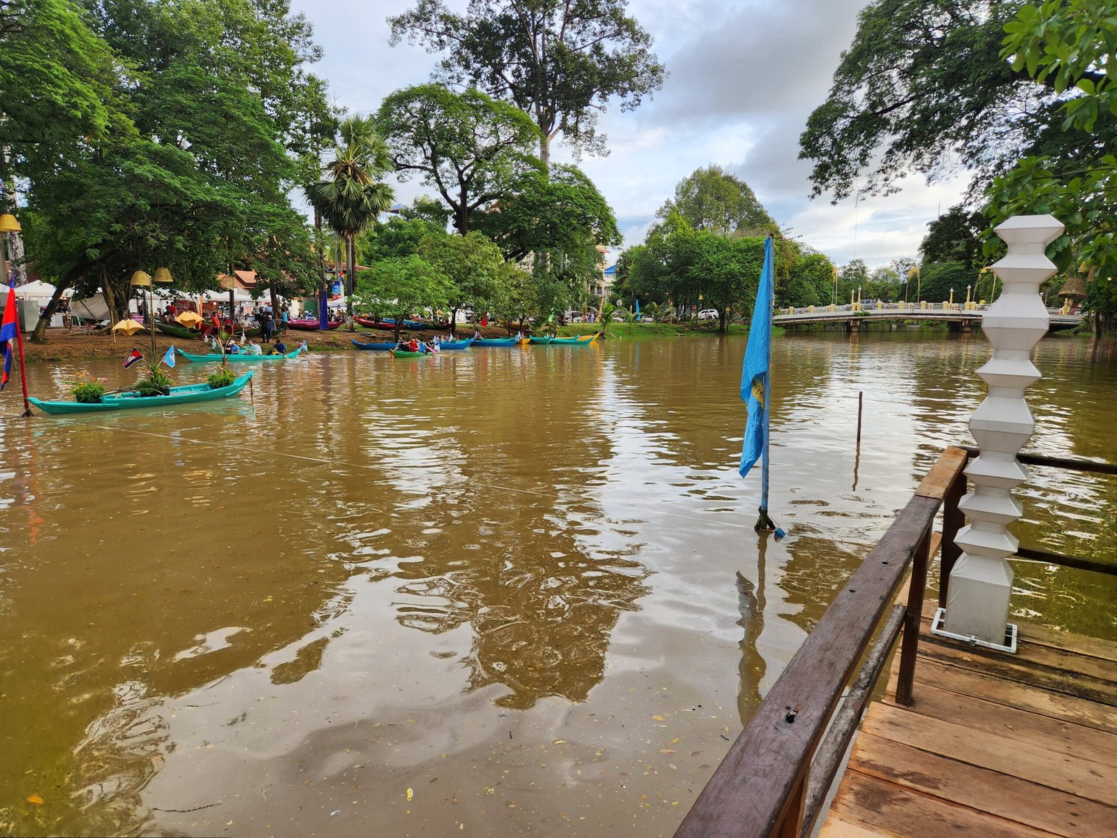 River view toward the bridge with canoes and a blue flag