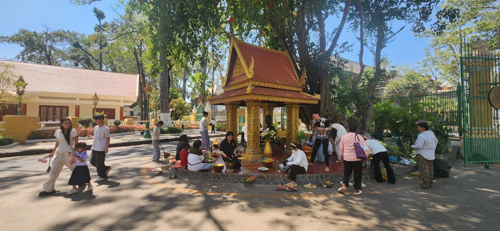 Worshippers gather at the golden pavilion beneath the sacred tree